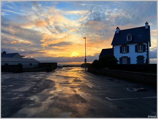 Vue d'une place en bord de mer à l'heure du coucher de soleil qui se reflète sur un sol mouillé